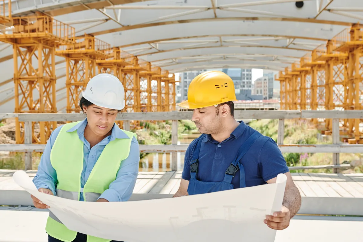 Two builders looking at plans on a construction site