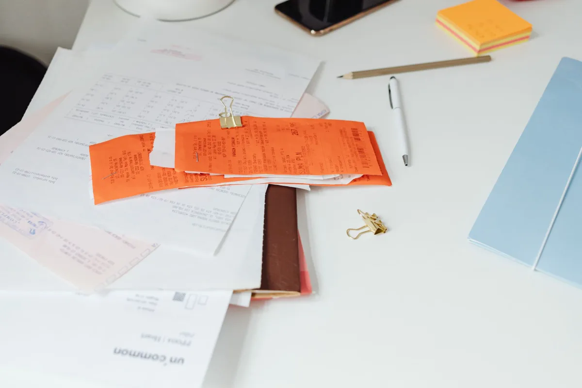 A tidy desk with receipts and documents arranged next to office supplies