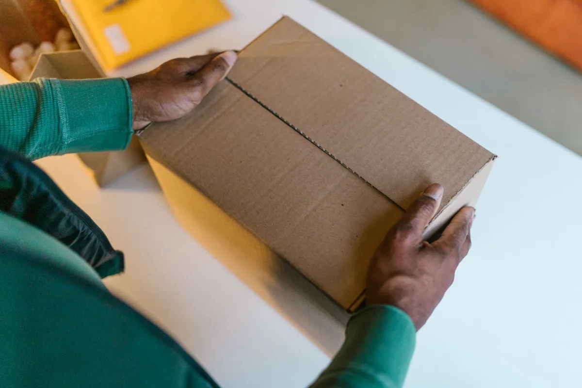 A courier checking a parcel and a clipboard at a doorstep