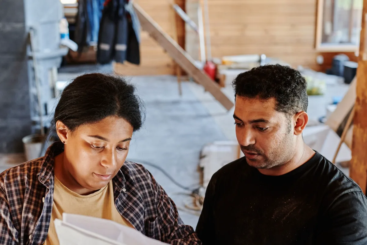A team looking at plans and a clipboard on a building site