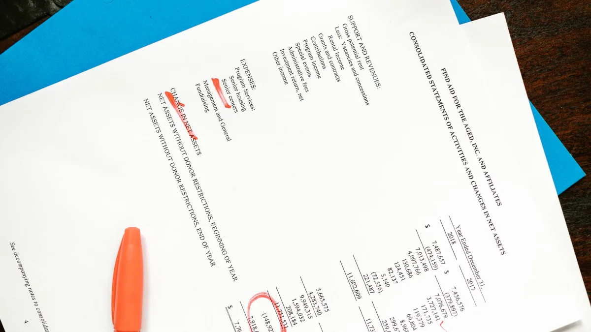 A printed list of items with red highlights and a marker on a desk